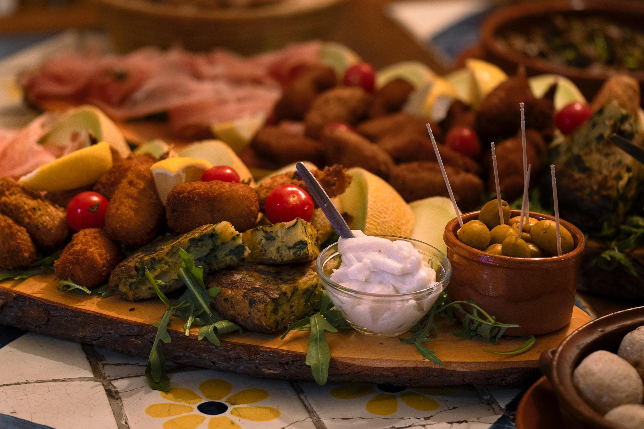 Antipasti board with croquettes, olives, and dip